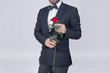 Man in suit holding a red rose 