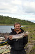 Fisherman holds his trophy salmon. Fishing on the Kola Peninsula, Russia.