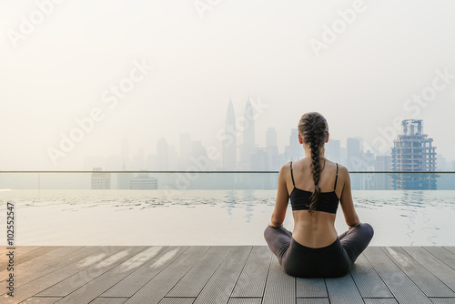 Fotografia, Obraz Relaxed young yoga woman in yoga pose near pool.