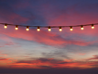 Wall Mural - light bulbs on string wire against sunset sky