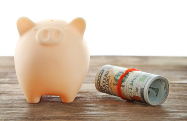 Wall Mural - Piggy bank with rolled dollars isolated on white