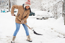 Woman Shoveling Snow In Parking