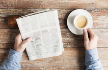 Close Up Of Male Hands With Newspaper And Coffee