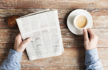 Poster - close up of male hands with newspaper and coffee