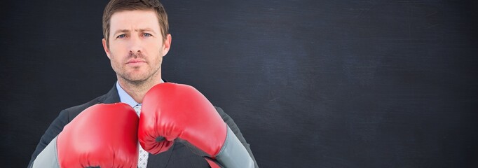 Wall Mural - Composite image of businessman with boxing gloves