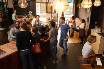 Wall Mural - Customers at the counter of cafe being helped by barista