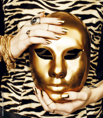 Naklejka na kafelki woman hands holding golden carnival mask, rich luxury manicure and jewelry close up on zebra print