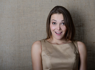 Portrait of emotional surprised young woman over canvas backgrou