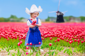 Wall Mural - Dutch girl in tulip field in Holland