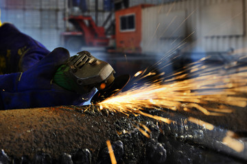 Worker during use electric wheel grinding 