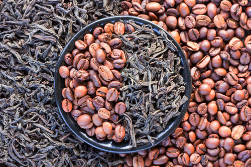 Fototapeta na wymiar coffee beans and black tea leaves in a round saucer