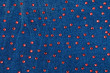 Abstract background with red rhinestones on denim