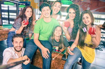 Best friends taking selfie at billiard pool table with back lighting - Happy friendship concept with young people having fun  - Vintage filtered look with soft focus on face due to sunshine halo flare