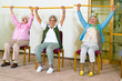 Three happy elderly ladies doing exercises.