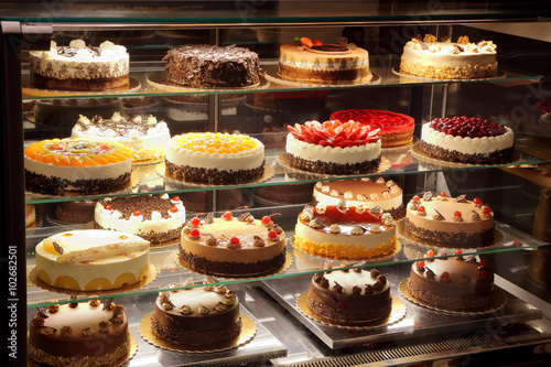 Cuadros en Lienzo Different types of cakes in pastry shop glass display