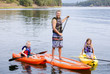 © Brocreative - Attractive family kayaking and paddle boarding together on a beautiful lake