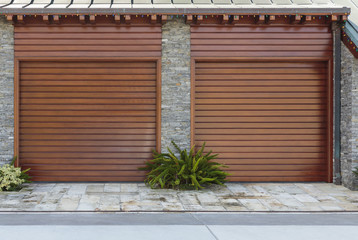 Two brown garage doors with strong vertical lines