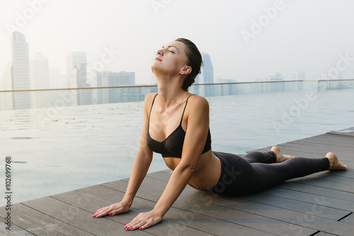 Obraz na plátne Relaxed young yoga woman in yoga pose near pool.