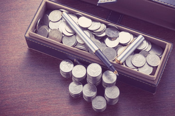 money concept coins and pen with filter effect retro vintage sty