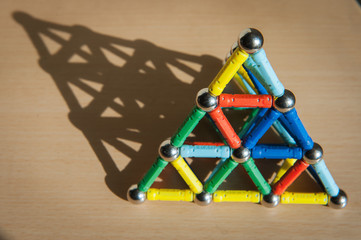 magnet toy pyramid on the desk with shadow