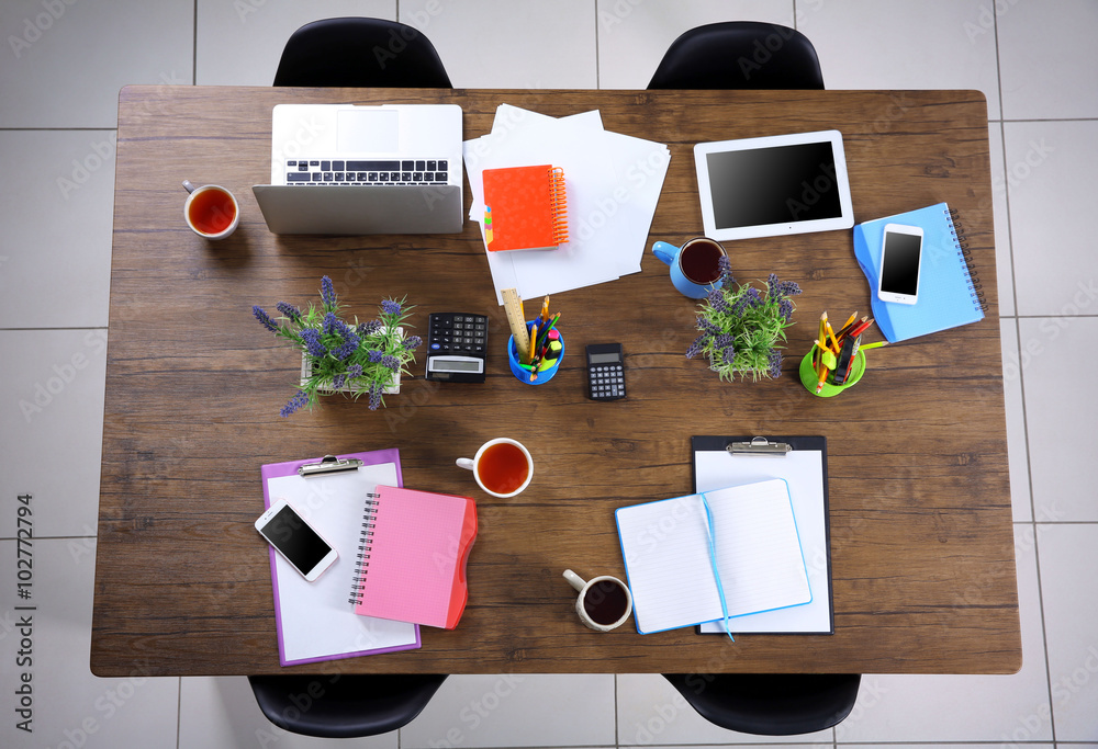 Session concept. Table with tablet, laptop, papers and cups of tea. Top view.