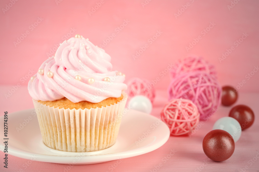 Tasty pink cupcake with decorations, closeup