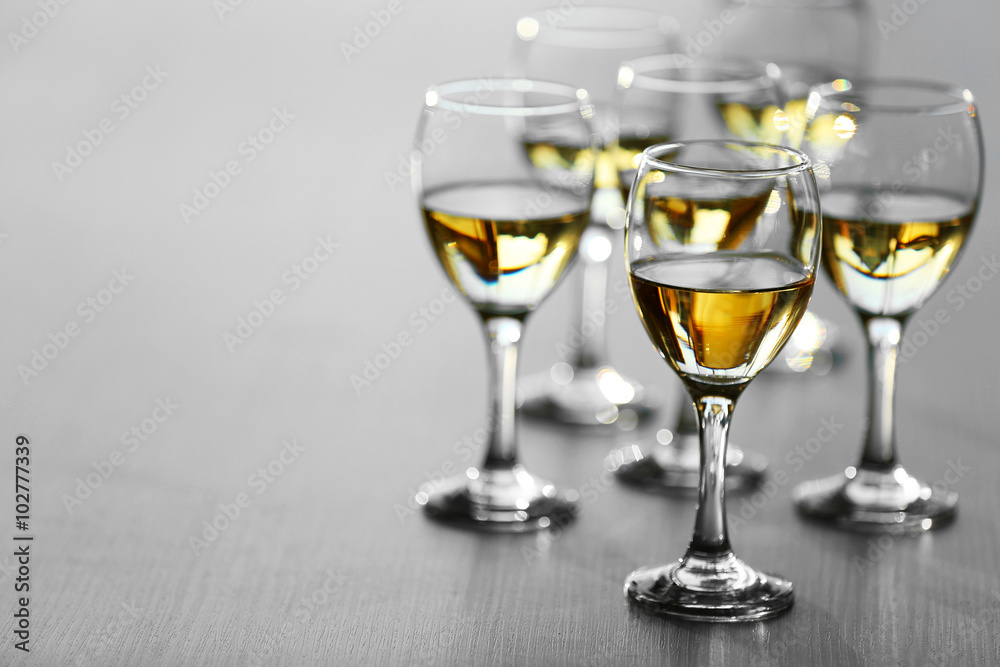 Glasses of wine on wooden blurred background