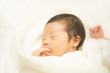 © dzono - タオルに包まれて眠る新生児