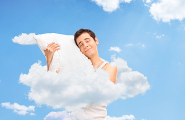 Wall Mural - Joyful man sleeping up in clouds in the sky