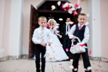 Wedding couple out from church registration, children strew peta