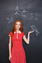 Beautiful Woman Holding Drawn Bird On Blackboard Background