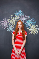 Poster - Attractive cheerful woman standing over blackboard with drawn flowers