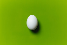 White Egg On The Green Background In Center
