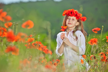 Beautiful kid in a red flowers field 