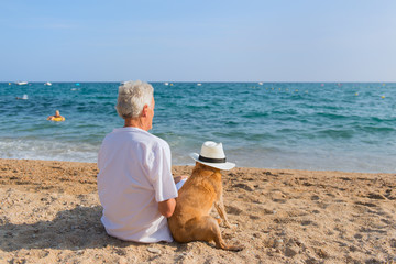 Senior man with dog at the beach