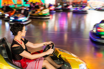 beautiful girl in an electric bumper car at amusement park