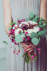 Wall Mural - Wedding bouquet of flowers, young bride holding a bouquet of flowers. Image of wedding dress and floral bouquet.