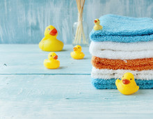 Stack Of Colorful Towels And Bath Duck On The Table