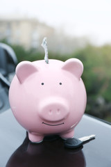 Poster - Piggy money box with cash and key on car bonnet at the street