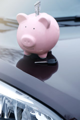 Poster - Piggy money box with cash and key on car bonnet at the street