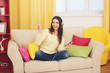 © Africa Studio - Happy young woman with headphones listening to music on a sofa at home