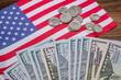 American flag with banknotes and coins