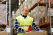 © Syda Productions - man in safety vest packing box at warehouse