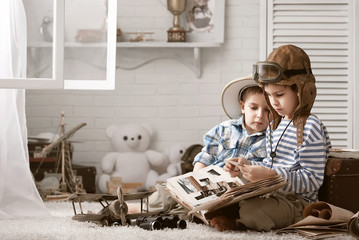 Boys in images traveler and pilot play in his room