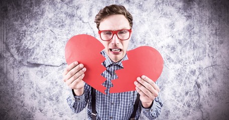 Poster - Composite image of geeky hipster holding a broken heart 