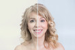 Before and after skin treatment transformation of a mid aged blonde woman smiling 