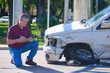 © Michael O'Keene - Male auto insurance adjuster inspecting a vehicle that has been in an accident wreck