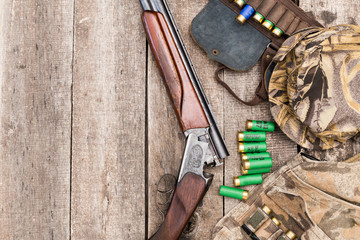 Wall Mural - Hunting shotgun and ammunition on wooden background