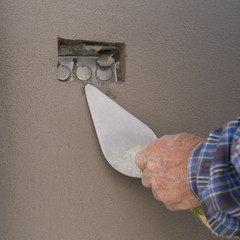 Canvas Print - hand using trowel to finish wet concrete wall at construction si