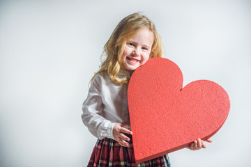 Wall Mural - Beautiful smiling blond girl in a school uniform with a big red